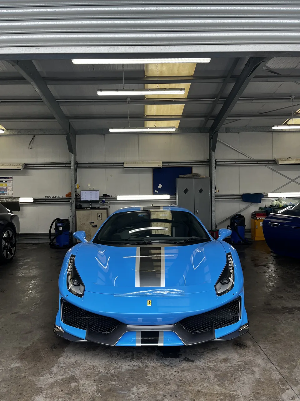 Blue Ferrari pictured in a detailing workshop