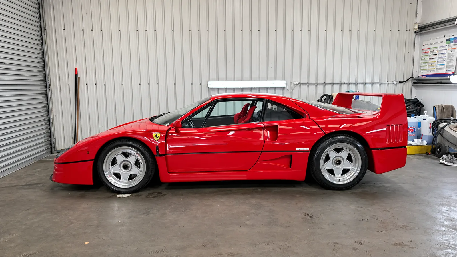 Red Ferrari F40 side profile inside the detailing workshop
